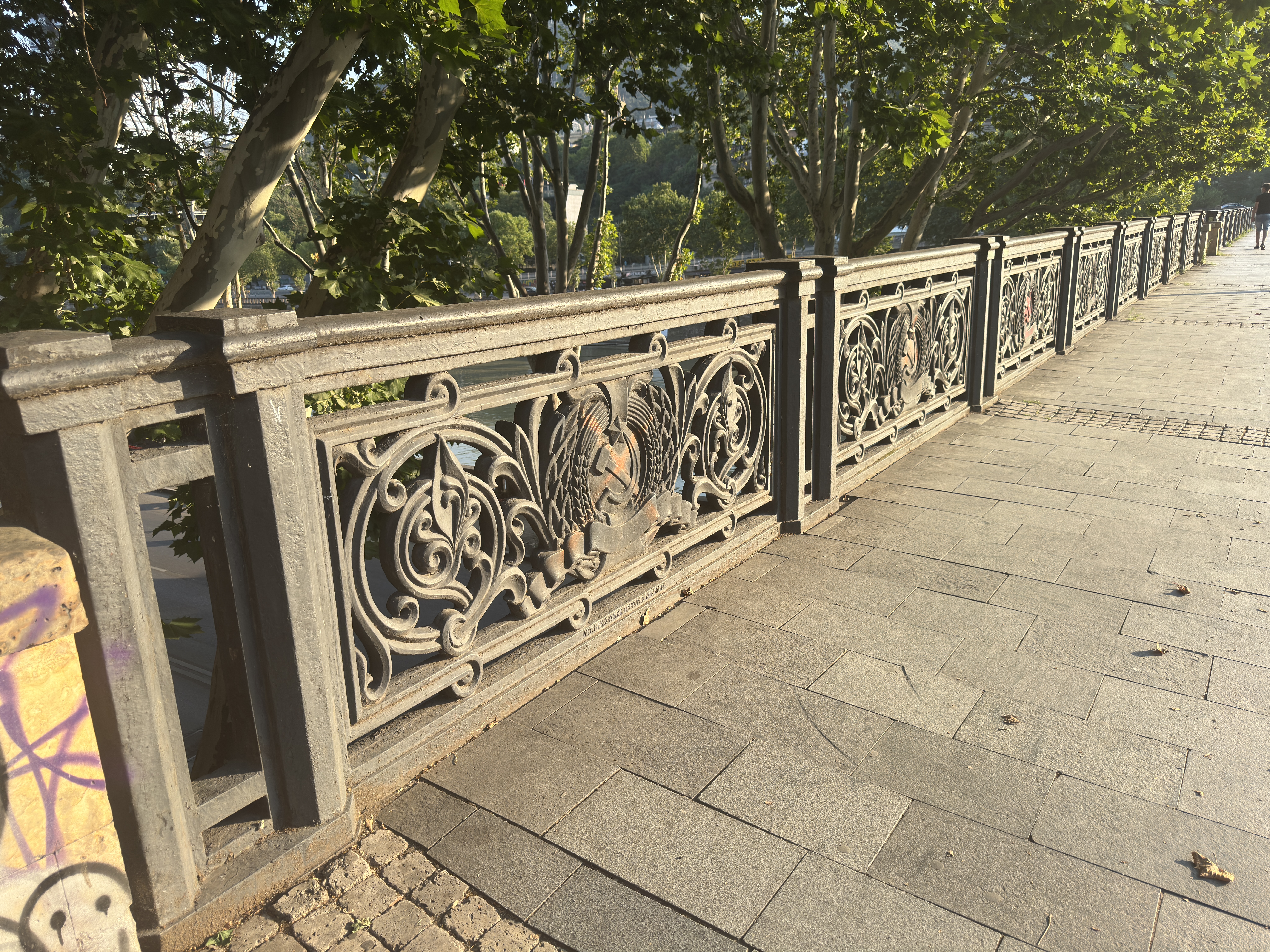 Row of cast iron panels with hammer and sickle reliefs on a bridge in Tbilisi.